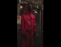 Red suit costume from Squid Game on train