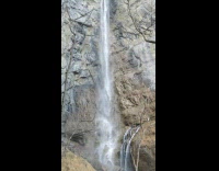 Huge waterfall camera pans upward nature mountain