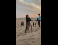 Guy photobomb woman black shirt hold sand 