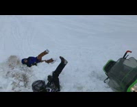 Guy rides snowmobile, files off ramp and jumps on friend 