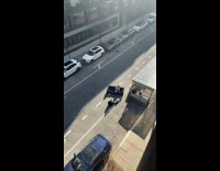 Woman in athleisure poses for photographer on old couch in street