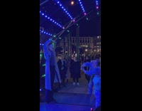 Woman films another woman with effort under the lights