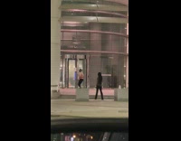 Woman pink sweater headphones dance  entrance building