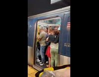 Lady holds pizza above packed train crowd