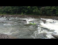 Green boat gets caught on rock guy falls off