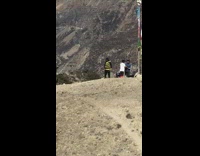 Black yellow sweater guy poses top mountain 