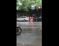 Three people dance pink shirt rain street