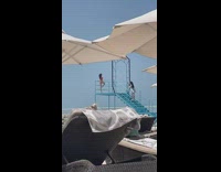 Woman in bikini poses on top of the tower stairs