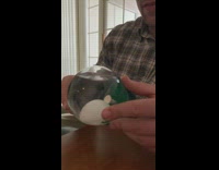 Guy shakes golf ball snow globe tee