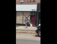 Guy drags cross on the sidewalk