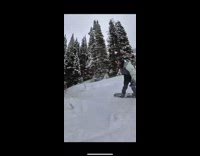 Guy riding snowboard down mountain hits tree