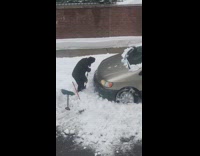 Guy uses cane to shovel snow car