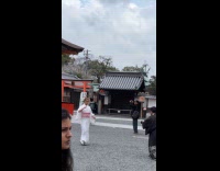 Woman white kimono tiktok dances near shrine
