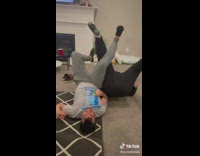 Two people leg wrestle and woman farts when interlock legs