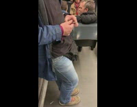 Guy fiddles with handcuffs on subway train