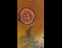 Guy speaks through yellow speaker in park