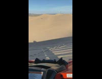 Guy hold white cloth sand dunes buggy