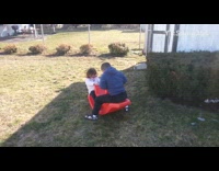 Boy swings on red seesaw and flips over girl on other side