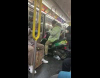 Guy sits on green scooter on subway 