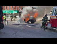 Firefighters hose down burning car 
