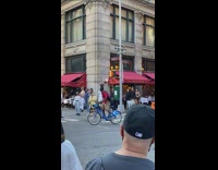 Guy balances basketball while riding bicycle around intersection