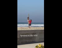 Woman bikini cling on wooden pole beach