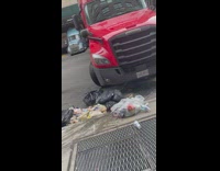 Truck drives over trash bags and spreads trash everywhere 