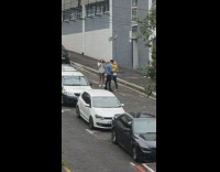 Couple poses on road incline yellow jacket