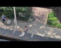 Blonde lady stands in boxes on sidewalk 