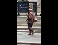 Man covered in copper paint walking