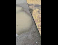 Muddy puddle at the drain on the unfinished road