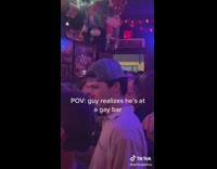 Guy white shirt looks around in pink color bar 