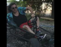 guy riding go kart gets handed drink and drinks it in slow motion 