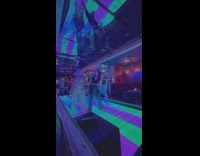 Three women dance on changing color tiles