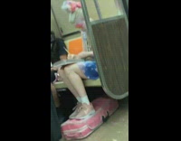 Woman in pink pastel cute outfit sits next to man black clothing on subway train