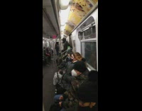 Guy standing up in subway train wearing a full oxygen mask