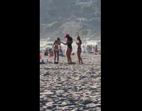 Two women pink cowboy hat dance beach