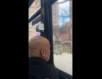 Man rides tractor with trailer on sidewalk