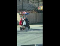 Guy rides mobility scooter with american flags 