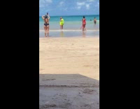 Woman green beach outfit dances at beach