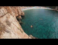 Guy backflip brown cliff side ocean water