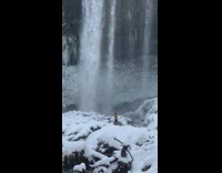 Guy shorts walk to cold snow waterfalls