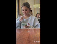 Girl at restaurant subtlety smoking out her vape in sweater