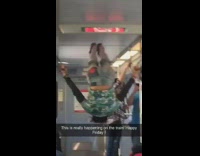 Man in palm tree shirt hangs onto handrails and flips upside down on the bus