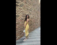 Girl yellow dress hold handbag brick wall