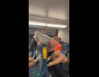 Guy sits on middle seat as friends push with their legs