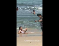 Guy brown shorts lays on side beach 