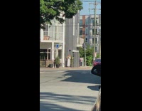 Lady takes photos of herself as an influencer on sidewalk 