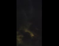 Storm clouds over city lights night flight