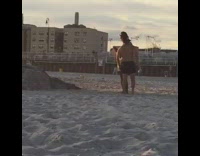 Guy in neon green shorts takes picture of friend jumping off rocks